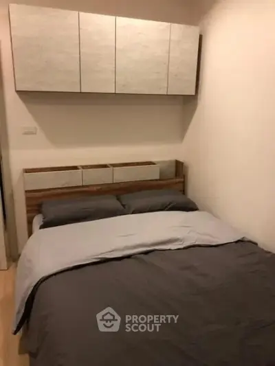 Cozy bedroom with modern cabinetry and stylish bedding in a compact space.
