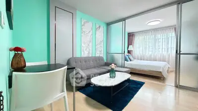 Modern living room with stylish decor and adjacent bedroom in open layout apartment.