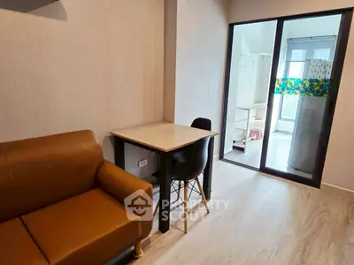 Cozy living room with brown sofa and dining table, sliding glass door to balcony.