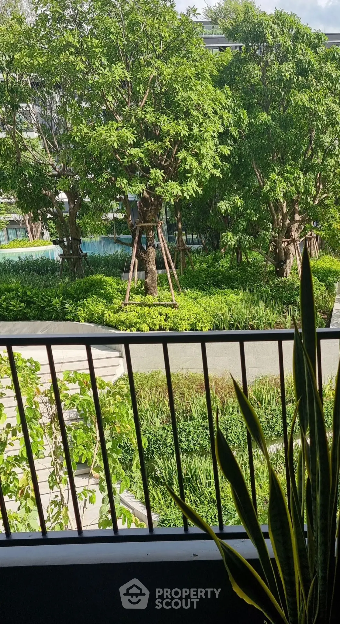 Lush garden view from balcony with vibrant greenery and serene ambiance.