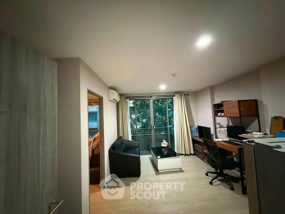 Modern living room with balcony view, sleek furniture, and natural light in urban apartment.