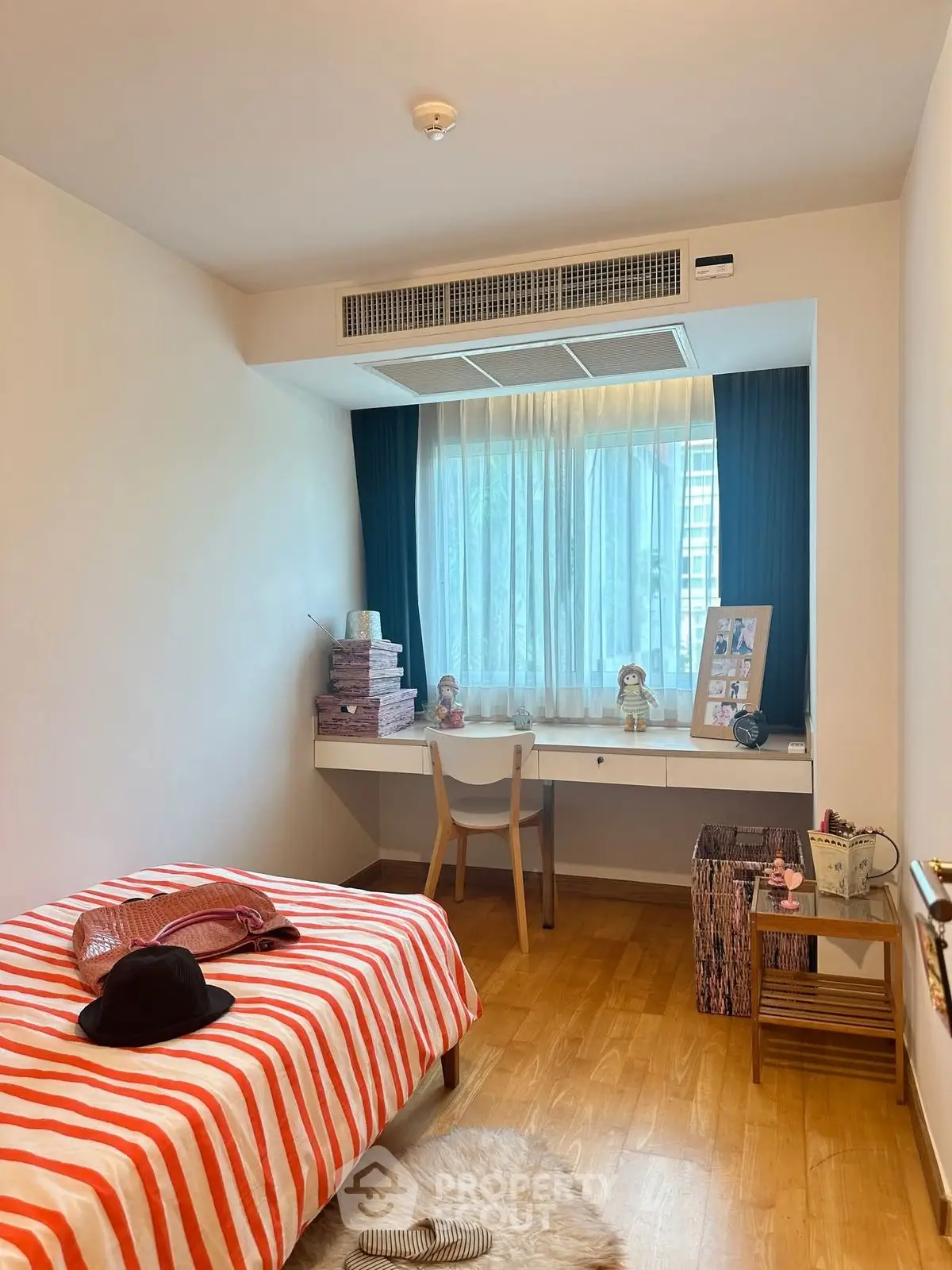 Cozy bedroom with stylish decor and natural light, perfect for relaxation and study.