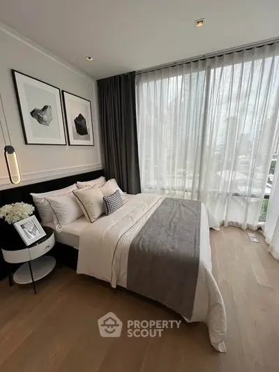 Luxurious bedroom with floor-to-ceiling windows and elegant decor in modern apartment.