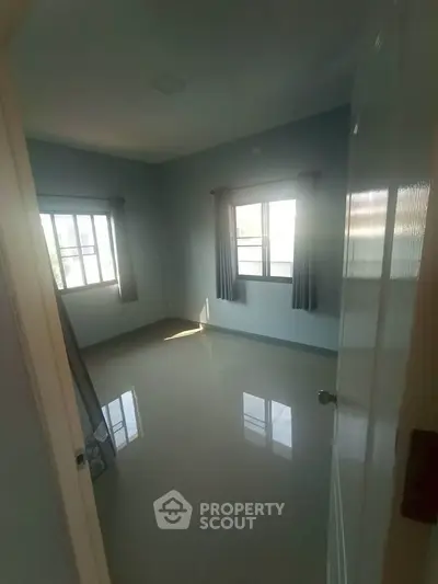 Spacious empty bedroom with large windows and natural light