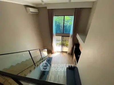 Spacious modern living room with high ceiling and large window view