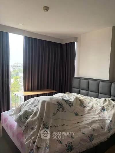 Cozy bedroom with large windows and modern decor in urban apartment