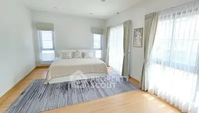 Spacious and bright bedroom with elegant decor and large windows