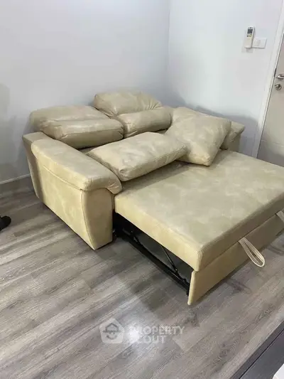 Modern beige sofa bed in a stylish living room with wooden flooring.