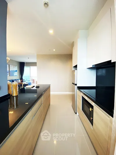 Modern kitchen with sleek black countertops and integrated appliances in a stylish open layout.