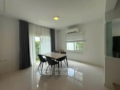 Spacious dining area with modern table and chairs, large windows, and natural light.