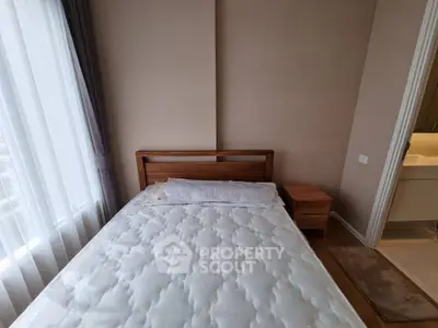 Cozy bedroom with natural light and modern wooden furniture, perfect for relaxation and comfort.