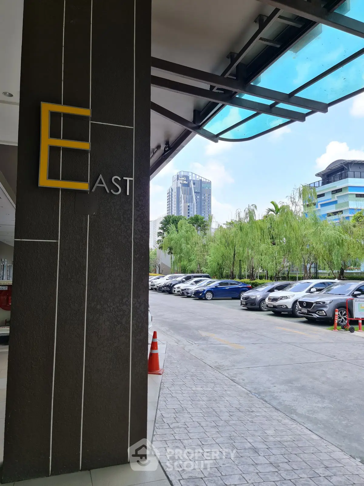 Modern building entrance with city view and parked cars