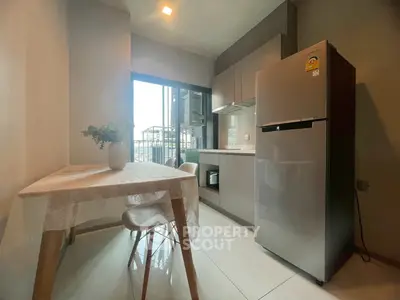 Modern kitchen with dining area and large fridge in a cozy apartment