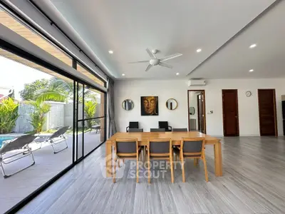 Spacious modern living room with pool view and elegant dining area, perfect for entertaining.