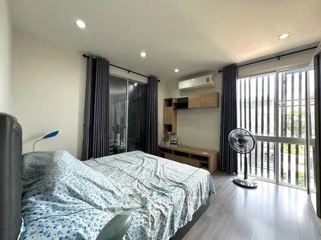 Spacious bedroom with modern decor and large window for natural light