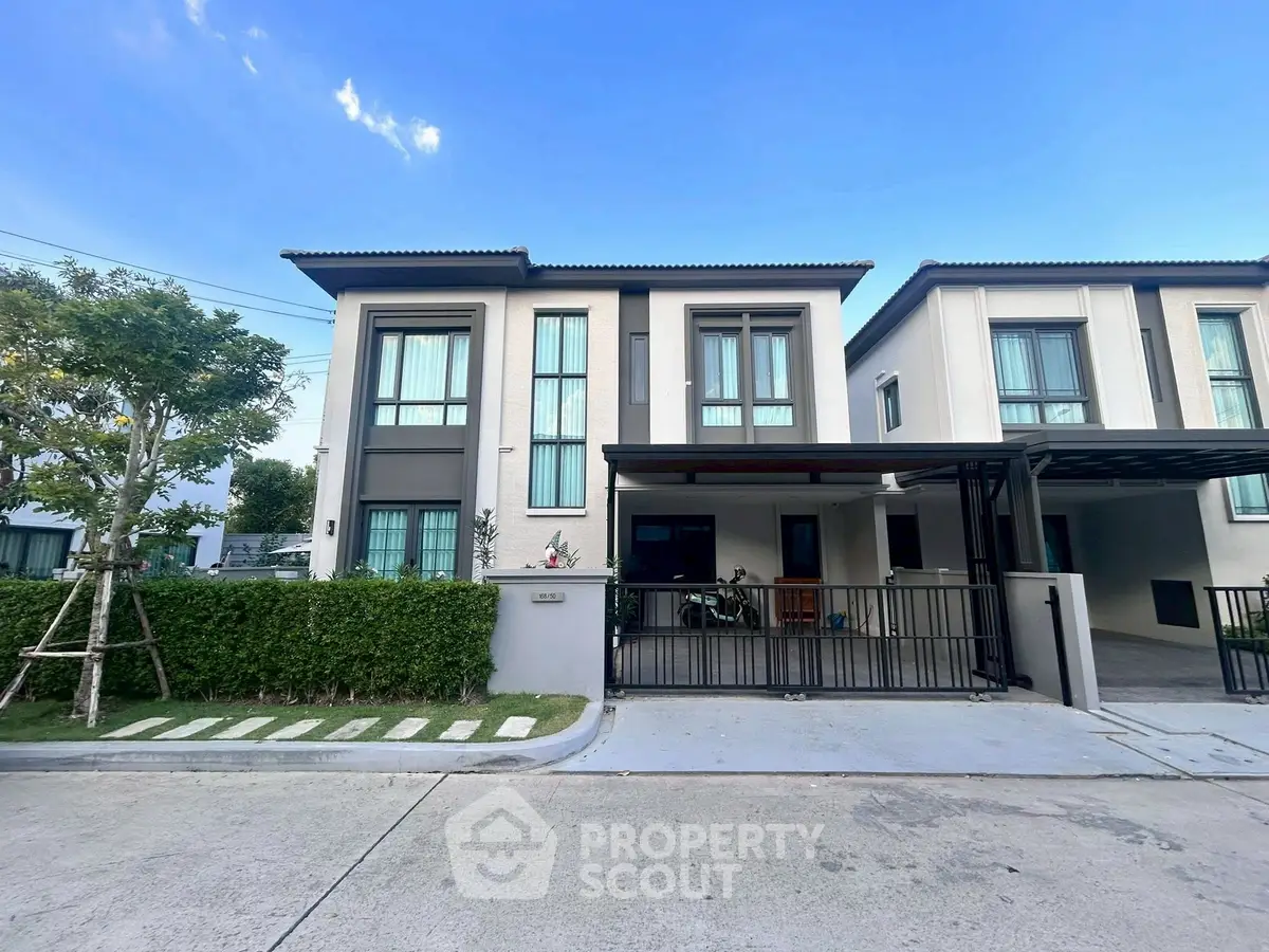 Modern two-story house with sleek design and spacious driveway in a serene neighborhood.