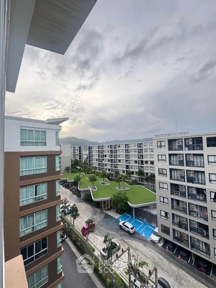 Modern apartment complex with green rooftop gardens and spacious parking area