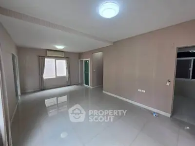 Spacious unfurnished living room with large windows and modern lighting
