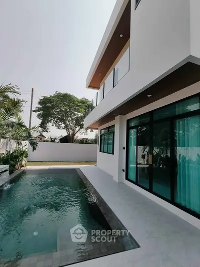 Modern luxury home with sleek pool and spacious outdoor area.