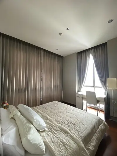 Cozy bedroom with elegant curtains and natural light, featuring a comfortable bed and a stylish desk area.