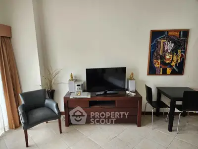 Modern living room with stylish furniture and wall art, featuring a TV and dining area.