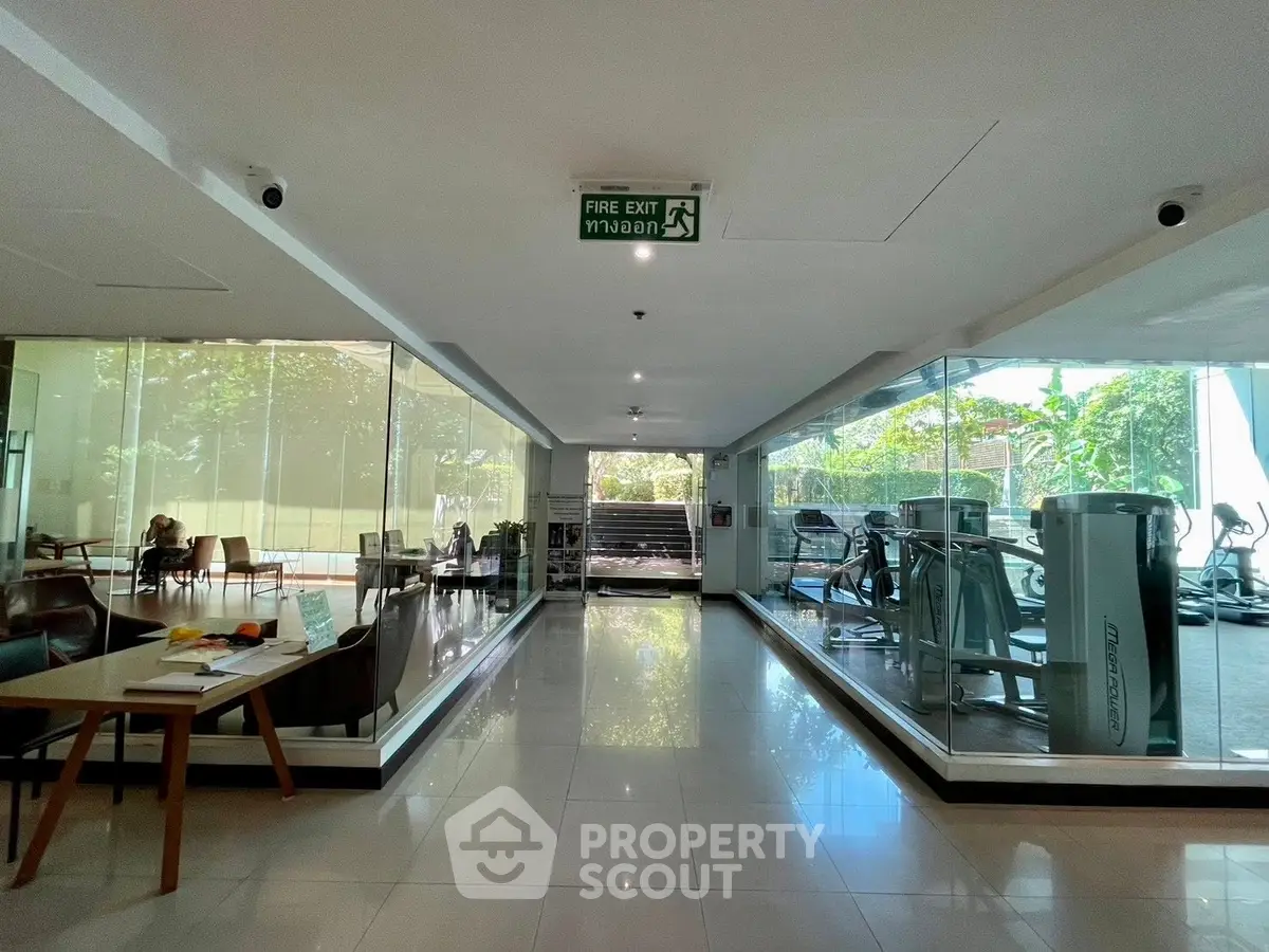 Modern gym with glass walls and lush garden view