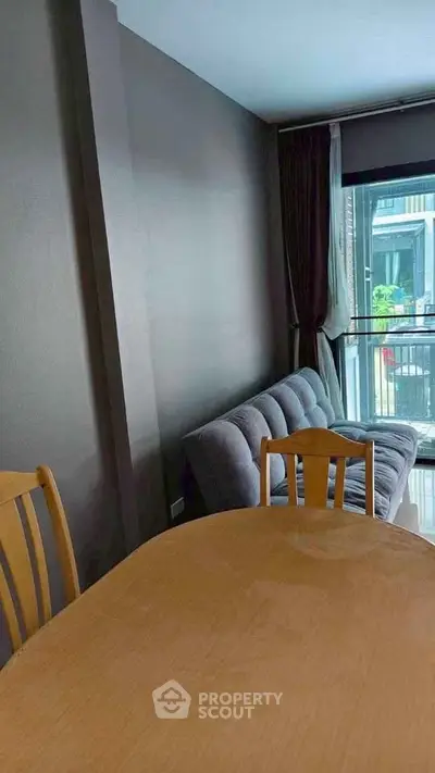 Cozy living room with modern sofa and dining table, perfect for relaxation and entertaining.