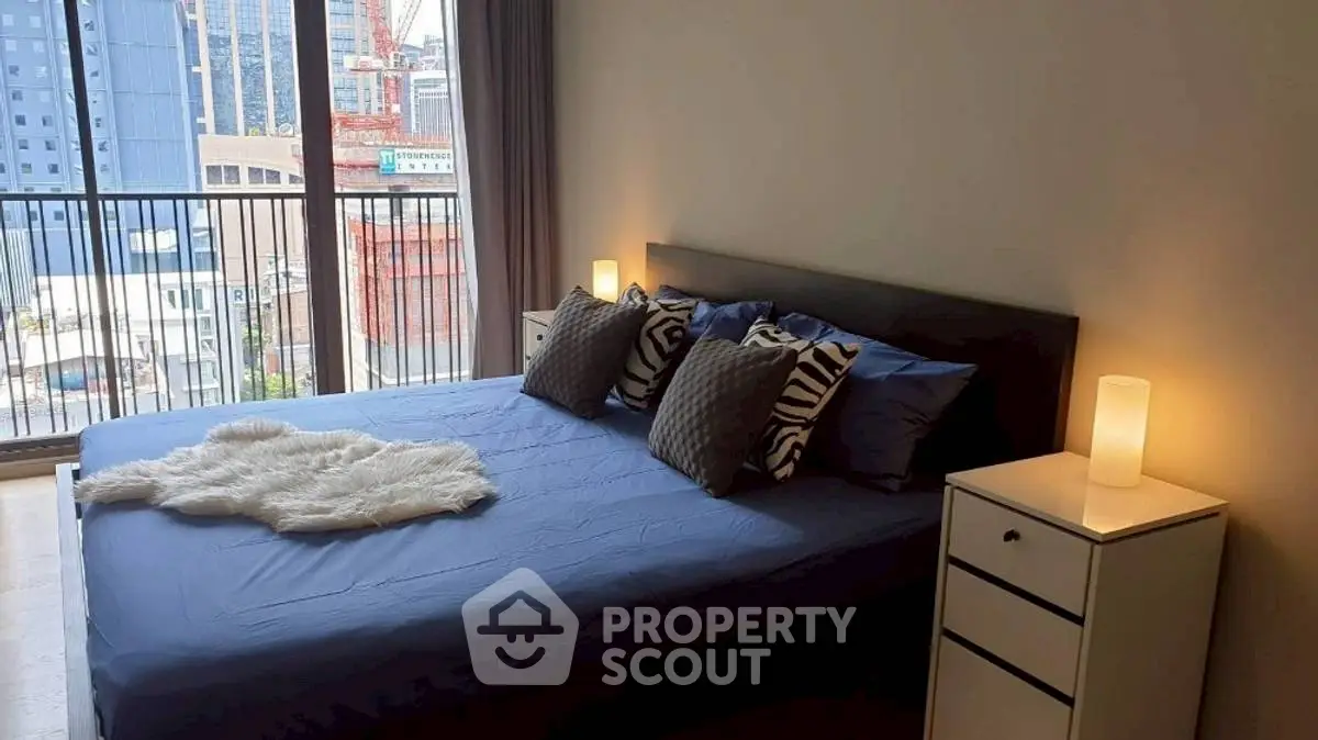 Modern bedroom with city view, featuring cozy bed and stylish decor.