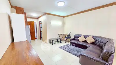 Spacious living room with modern leather sectional and cozy workspace