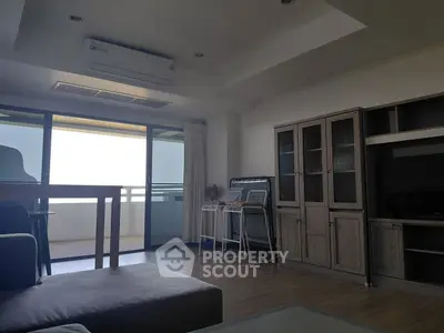 Spacious living room with modern furniture and balcony access in a stylish apartment.