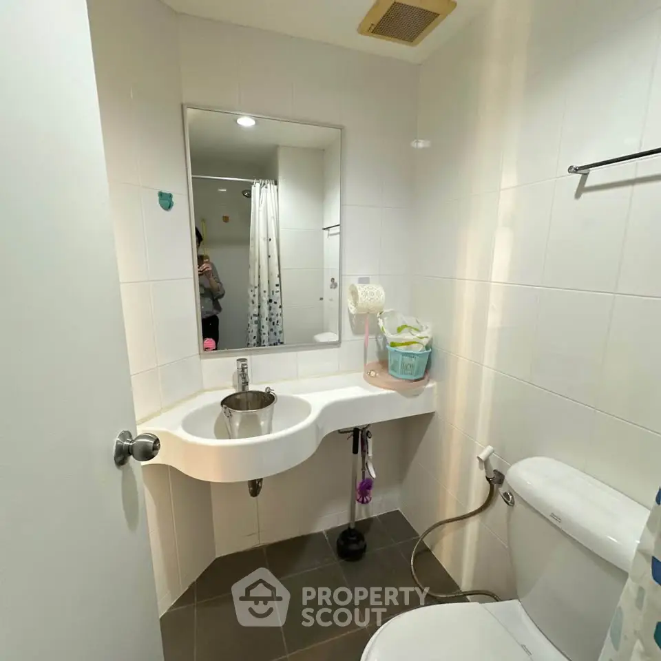 Modern bathroom with sleek fixtures and white tiles, featuring a compact design and contemporary style.