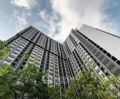 Stunning modern high-rise building with sleek architecture and lush greenery, perfect for urban living.