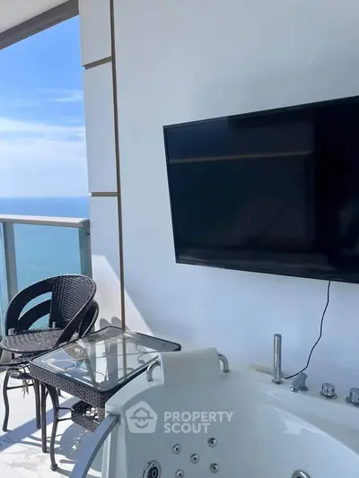 Luxurious balcony with ocean view, jacuzzi, and outdoor seating