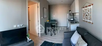 Modern living room with open kitchen, cozy sofa, and dining area in a stylish apartment.