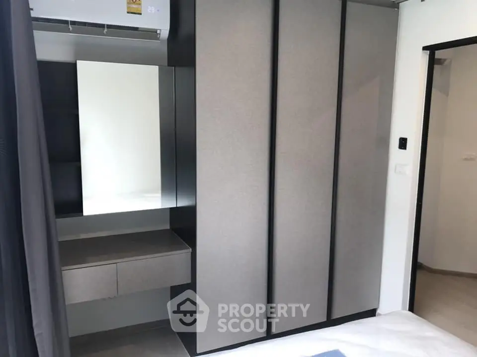 Modern bedroom with sleek wardrobe and vanity area, perfect for stylish living.