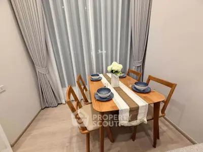Charming dining area with elegant wooden table set for four, featuring stylish curtains and cozy ambiance.