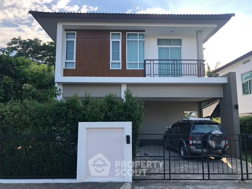 Modern two-story house with carport and lush greenery, perfect for family living.