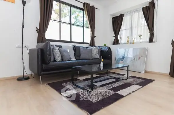 Stylish living room with modern black sofa and large window view