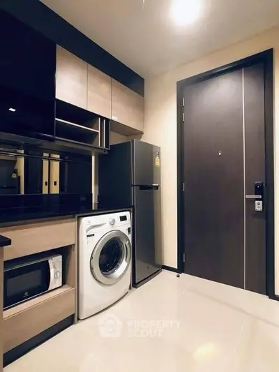 Modern kitchen with sleek appliances and stylish cabinetry in a compact layout.