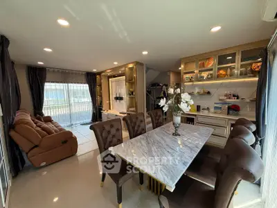 Luxurious open-plan living and dining area with elegant marble table and plush seating, perfect for entertaining.