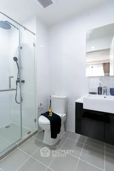 Modern bathroom with glass shower and sleek fixtures in contemporary home.