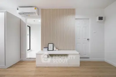 Modern minimalist living room with sleek white furniture and wood flooring