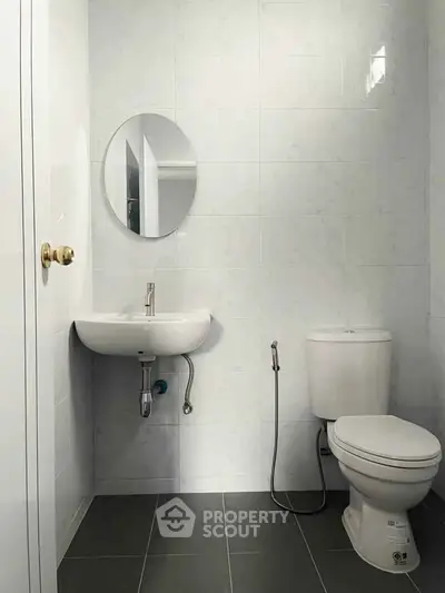 Modern minimalist bathroom with round mirror and sleek fixtures