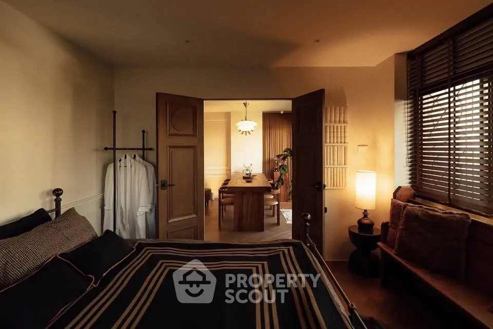 Cozy bedroom with stylish decor and view into elegant dining area