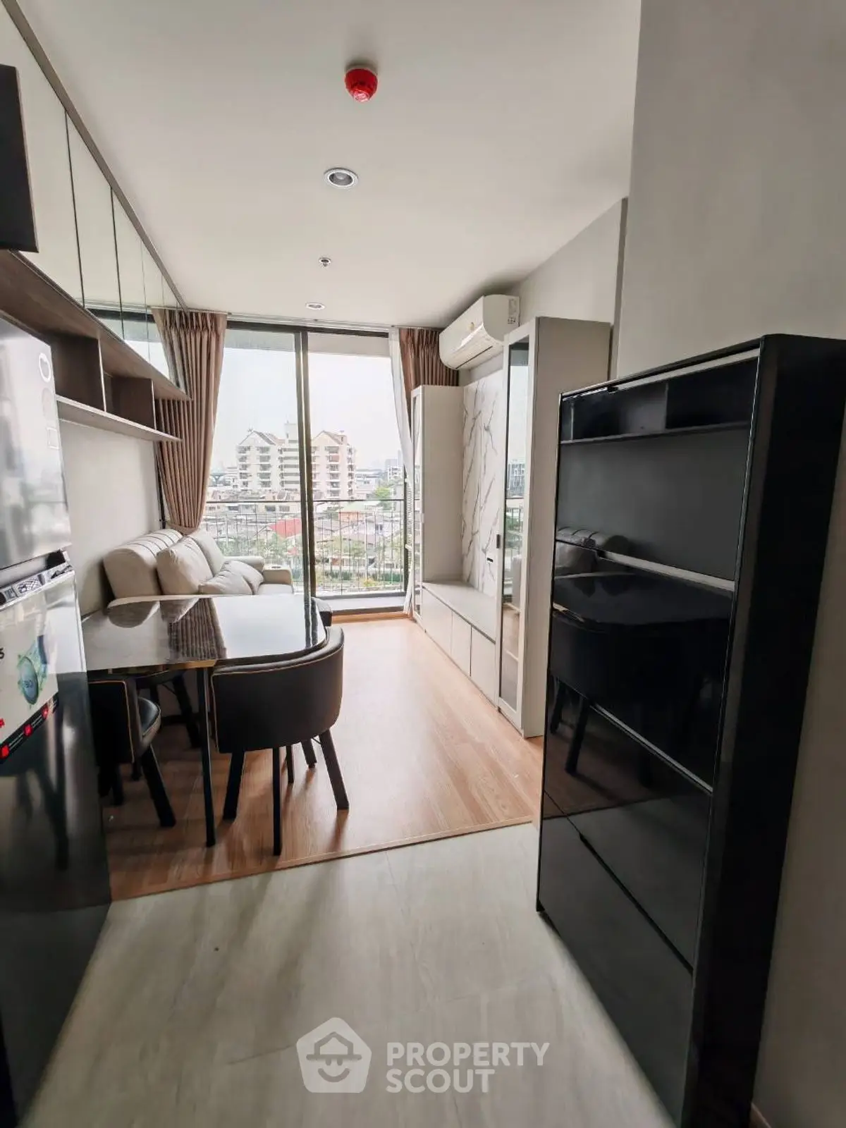 Modern apartment with open living and dining area, featuring a city view balcony.
