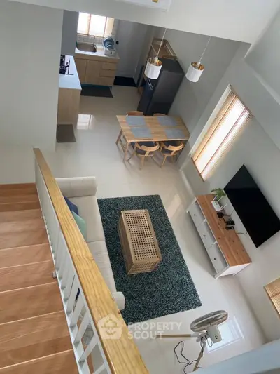Modern open-plan living room with kitchen, dining area, and stylish decor in a bright, airy space.