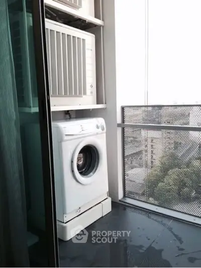 Compact balcony with washing machine and city view, ideal for urban living.