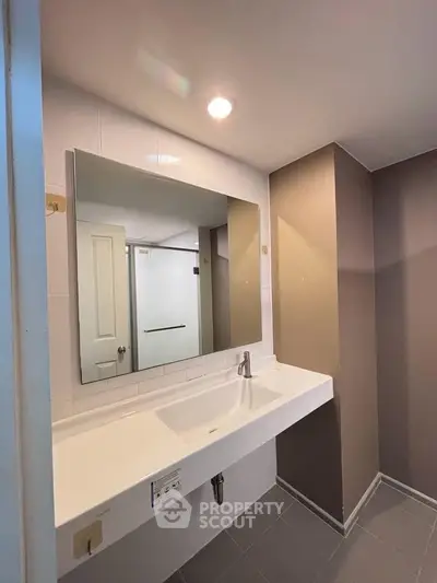 Modern bathroom with sleek design and large mirror in a contemporary home.