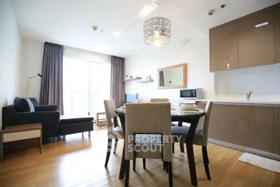 Modern open-plan living room and kitchen with elegant dining area and stylish lighting.