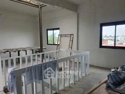 Spacious unfinished interior with large windows and potential for customization.